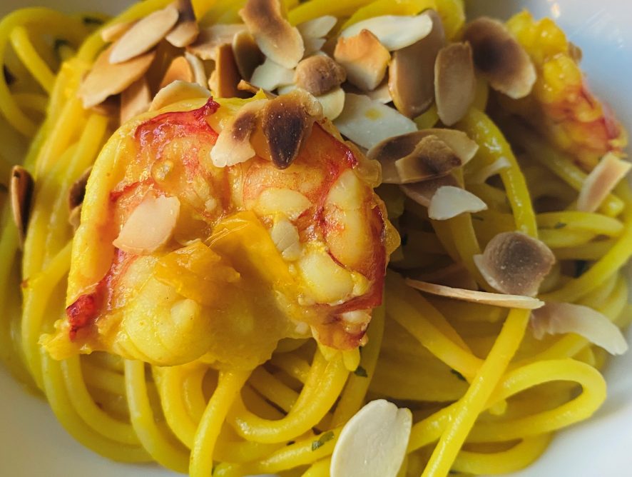 Spaghetti con crema di pomodorini, gamberoni e mandorle